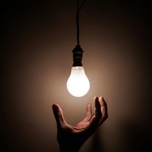 Person Holding White Light Bulb